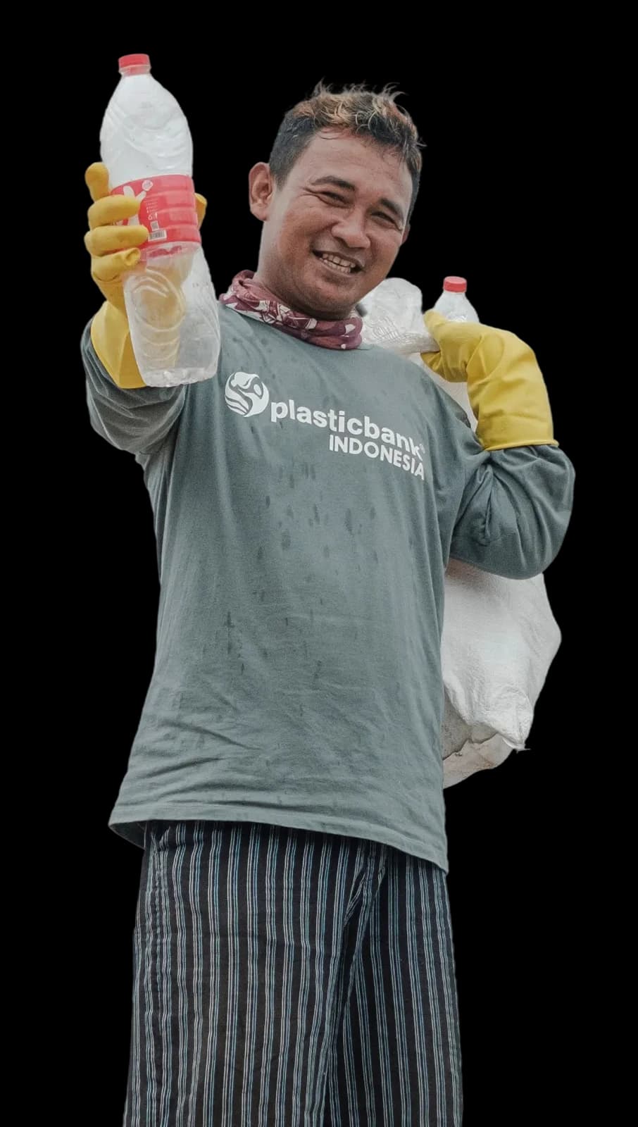 Juhari, a Plastic Bank collection member in Bali, standing with a sack of gathered plastic