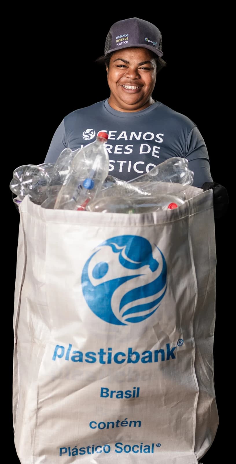 Vanessa, a Plastic Bank collection member in Itaguai, Rio de Janeiro, standing with gathered bottles