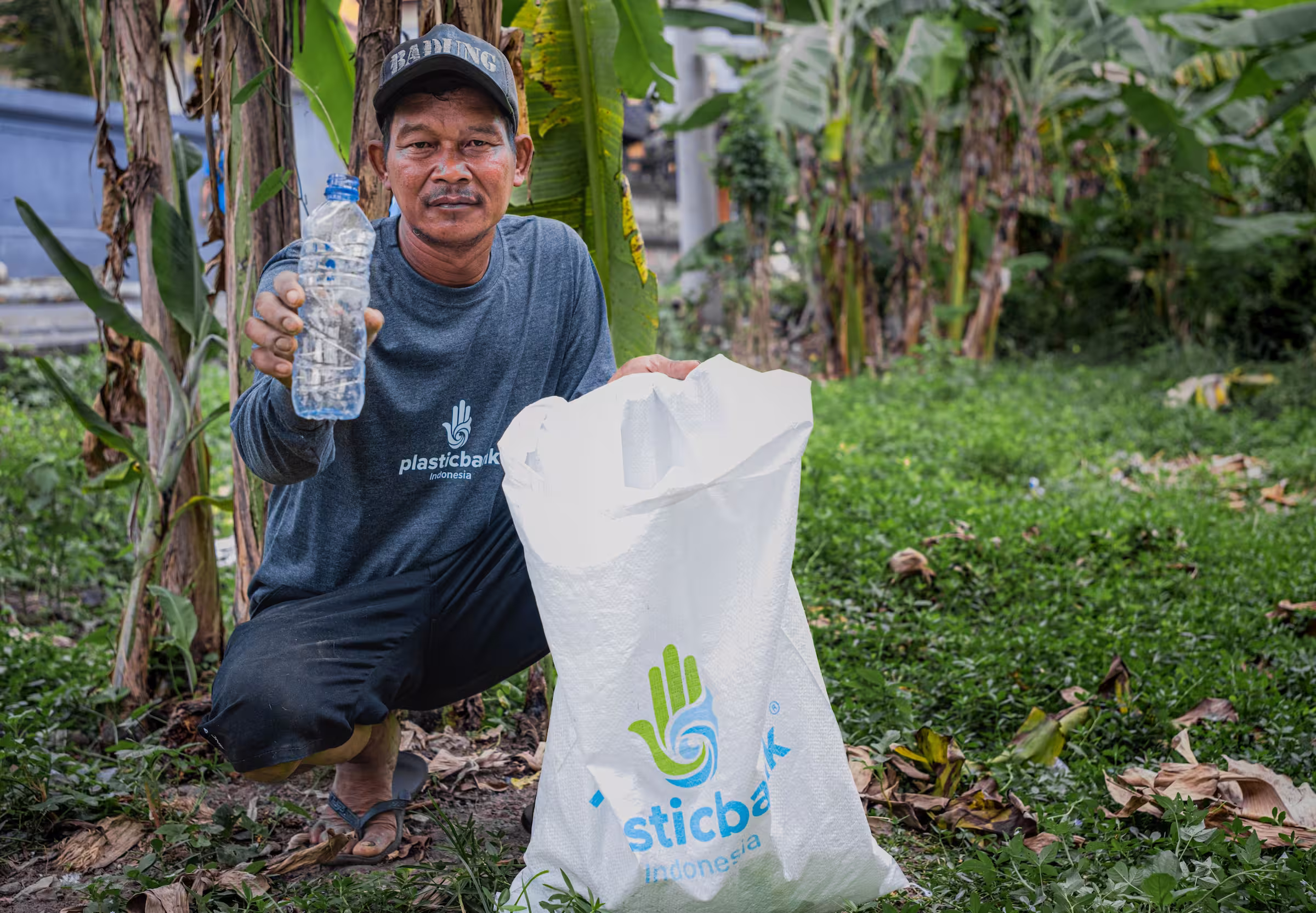 plastic bank member collecting and showing plastic bottle